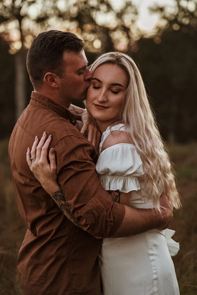 Couple photoshoot where couple is embracing at sunset in Gold Coast field